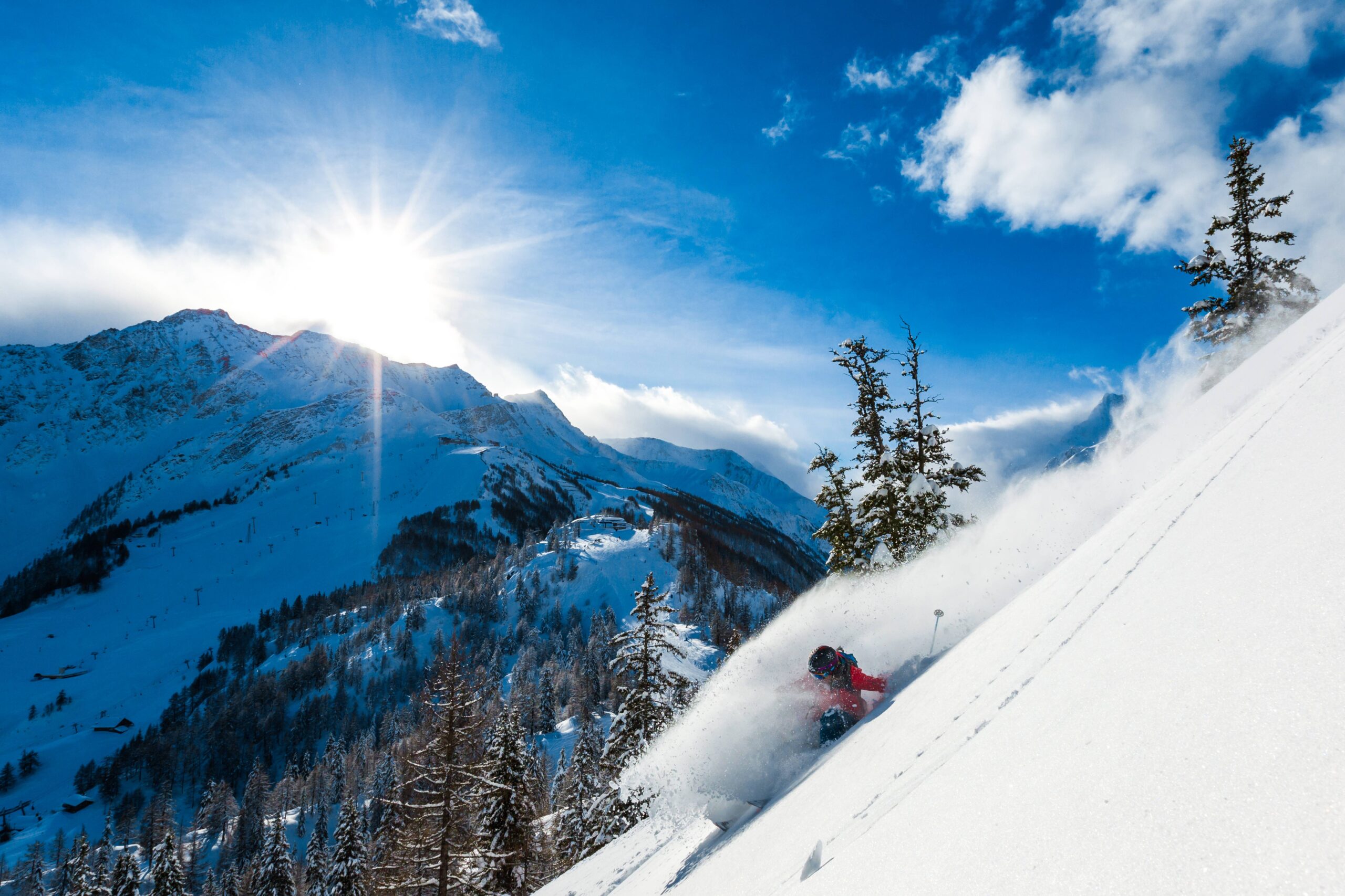 skier sprays snow on a steep, remote off-piste slope in Courmayeur