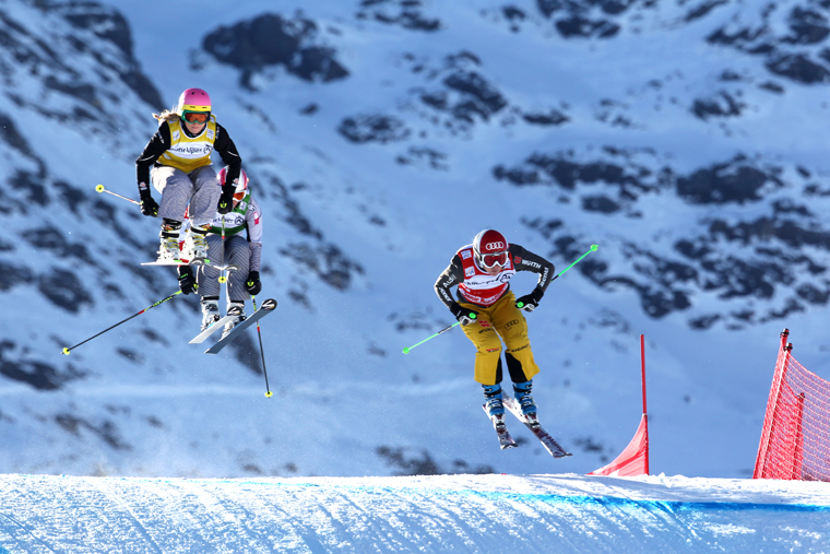 three skiers in air on a Ski Cross course