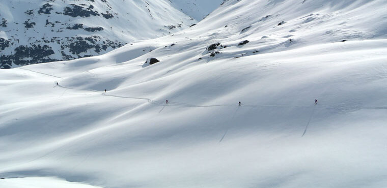 skiers touring through mountains