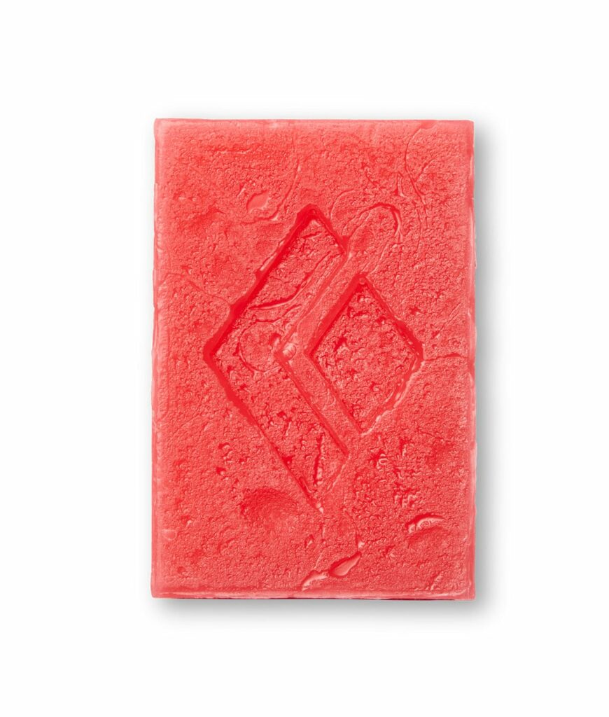 A block of black diamond glide ski wax in red