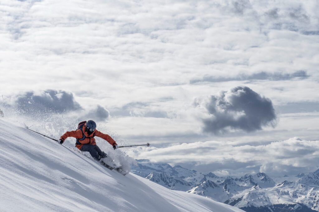 skier on a big turn on the slopes of baqueira beret in front of clouds in background