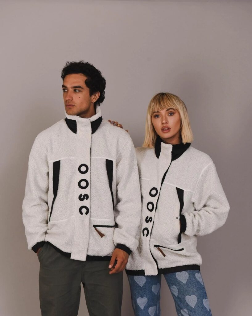 OOSC white and black fluffy fleece Sherpa jackets being modelled by a man and a woman