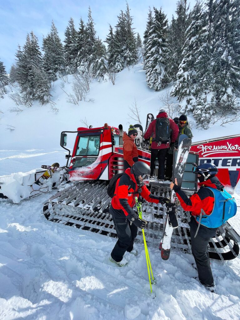 skiers climb aboard a cat for off piste skiing in ukraine. Lots of snow on ground