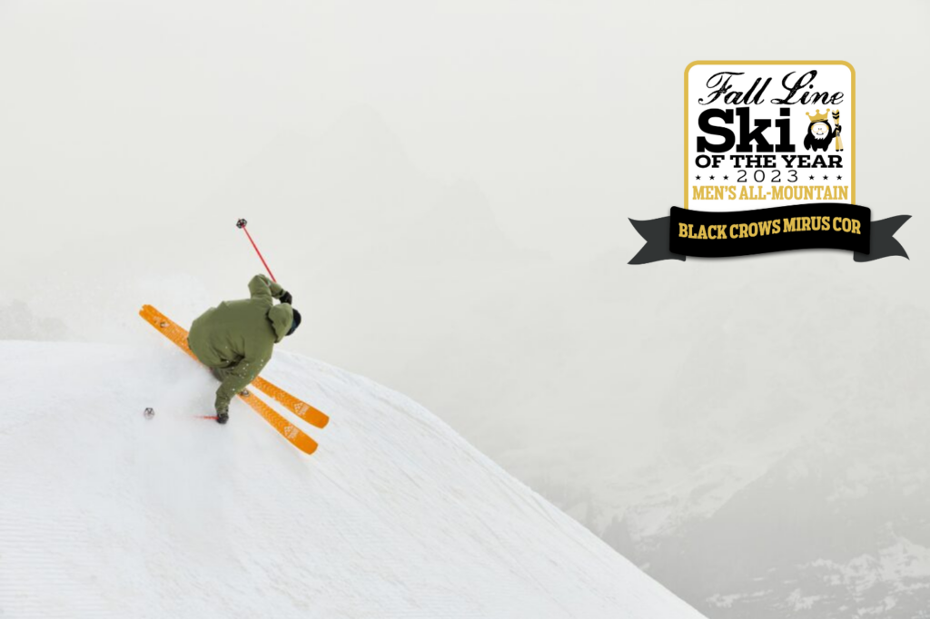misty, white-out scene with skier on orange skis on mega air
