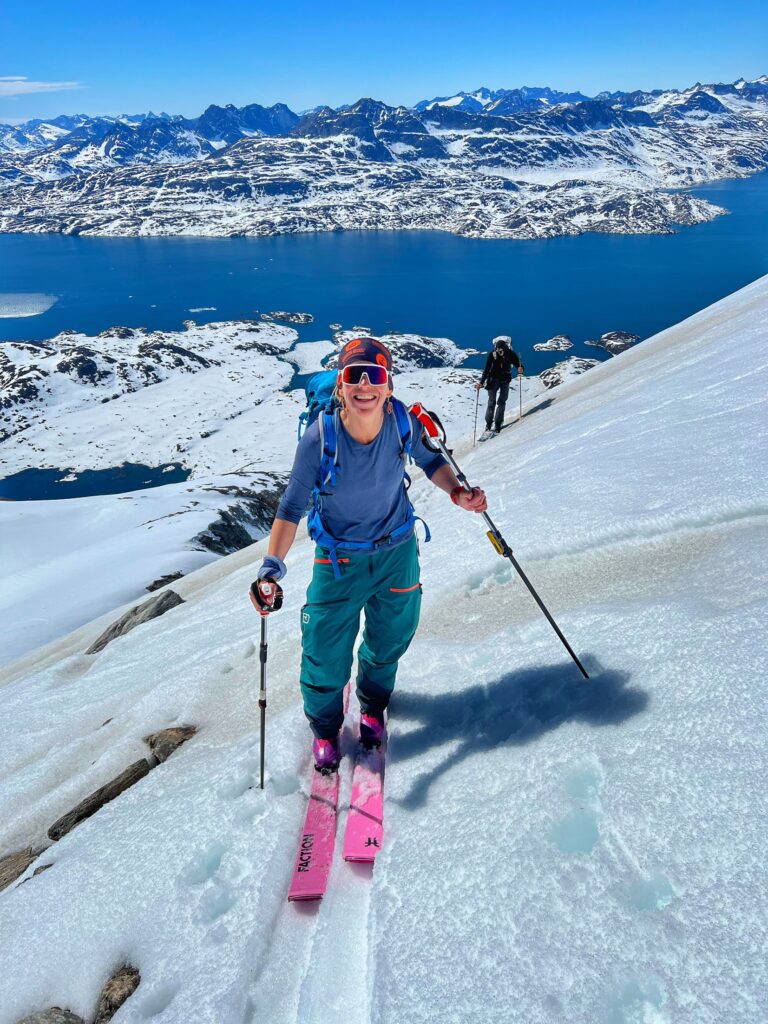 Fall Line gar editor and ski tester Soph Nicholson on touring skis above  fjord like looking body of water