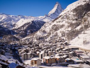 lightly dusted village of zermatt sits in a cradle of mountains with matterhorn rising high as backdrop