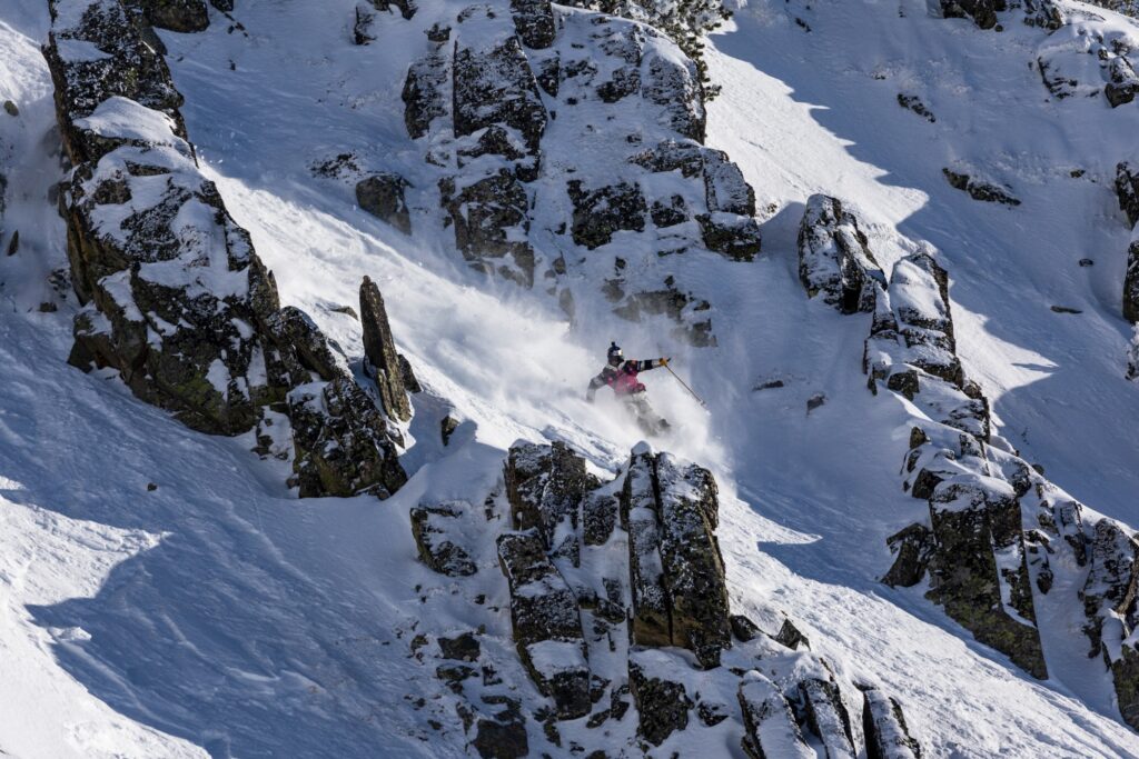 skier freeriding between big rocks in snowy baqueira beret in spain