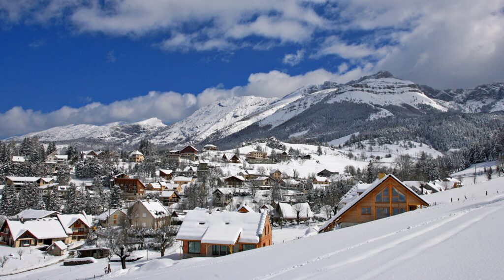 pretty alpine village covered in snow with medium mountains surrounding