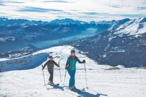 two ski tourers skin up in spring conditions on hard pack snow