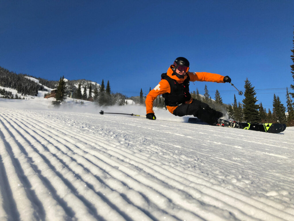 ski patroller carves deep on perfect groomed corduroy