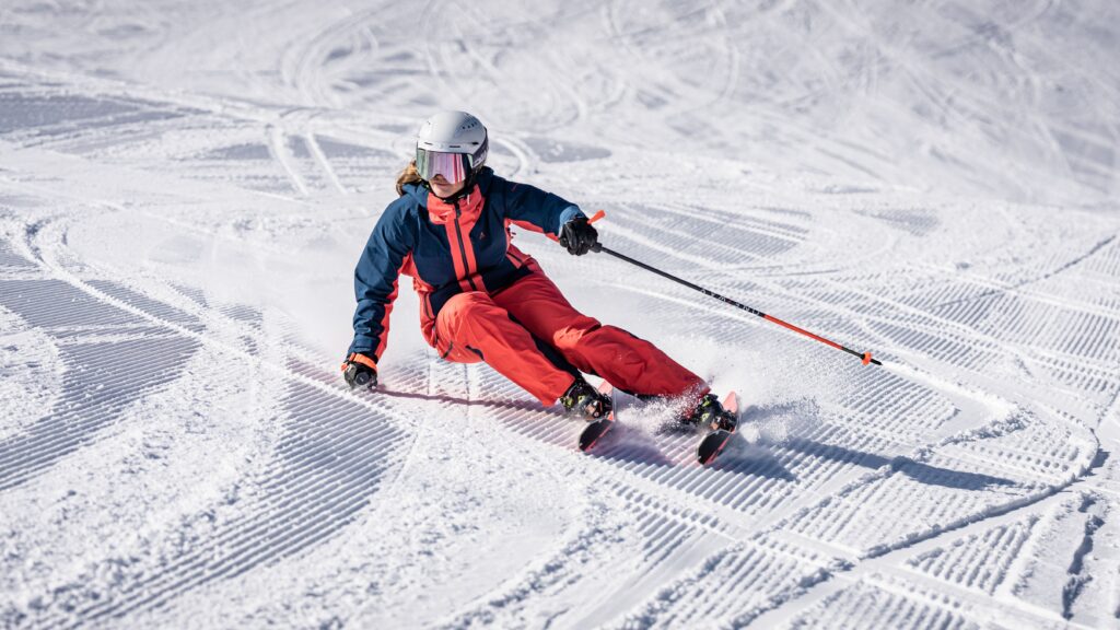 a perfect carve turn by female skier on groomed piste