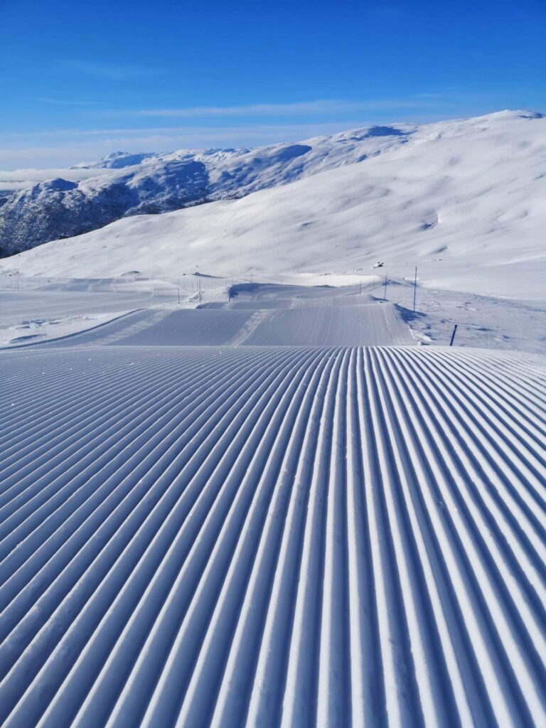 pristine corduroy from a grooming machine, camera placed on the snow to capture