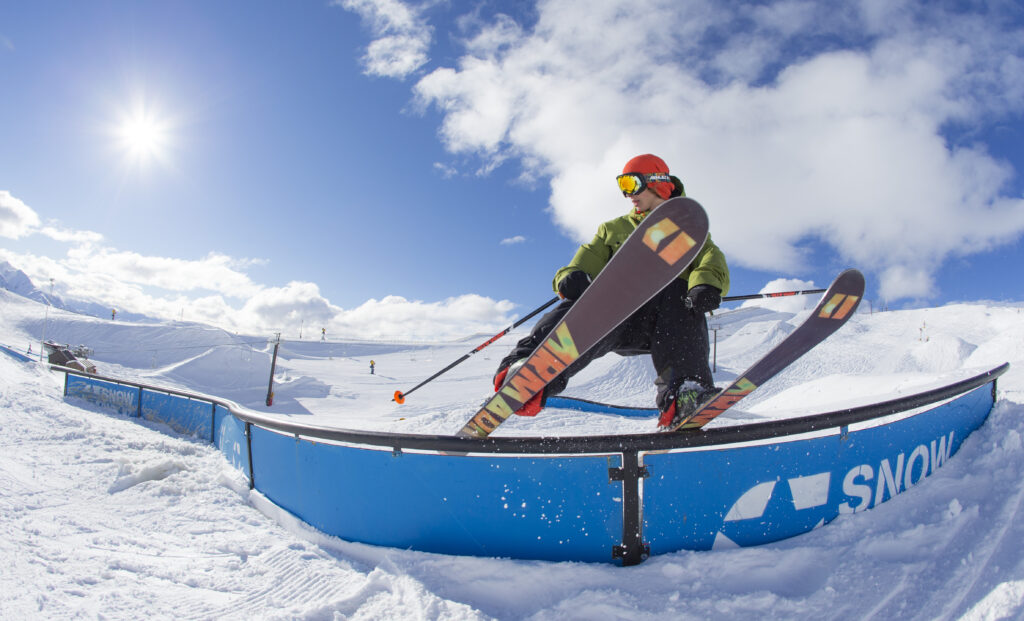 skier (with armada bases to the skis in frontal shot) makes a rail slide