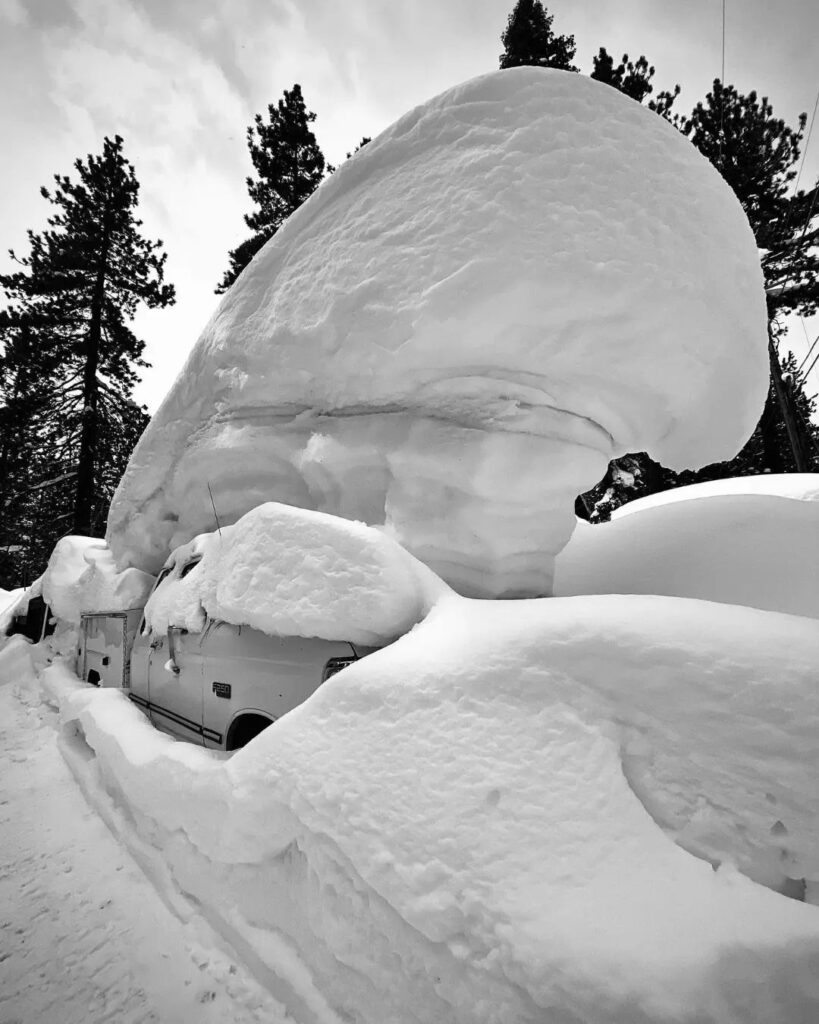 massive snow mushroom on top of car, metres deep, in black and white shot