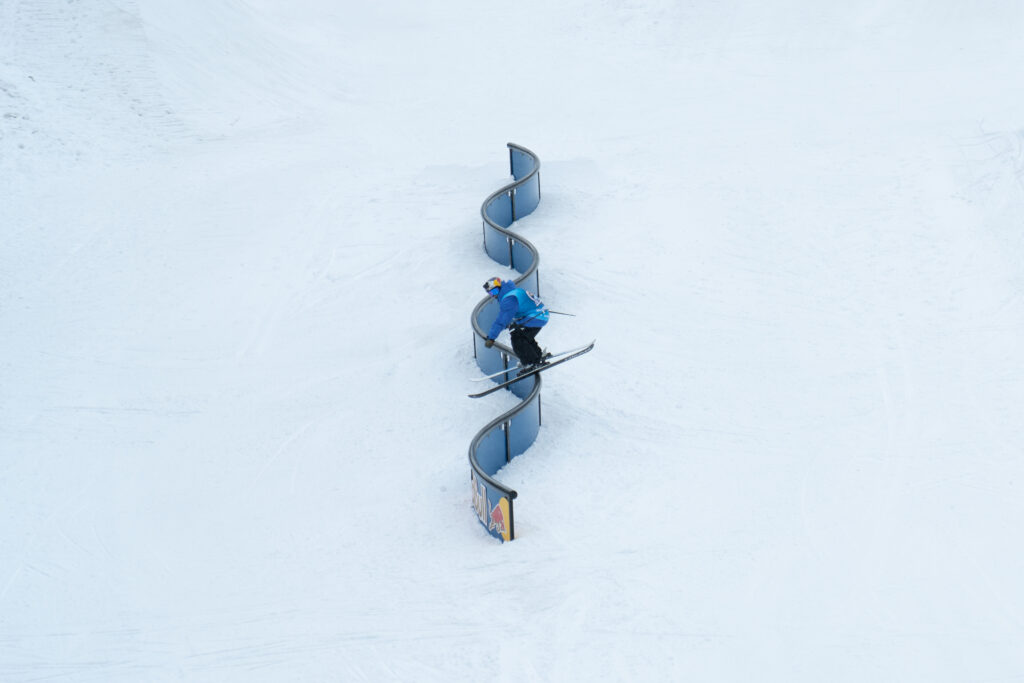 park skier shot from birds eye view on a curved rail with six S-shape bends