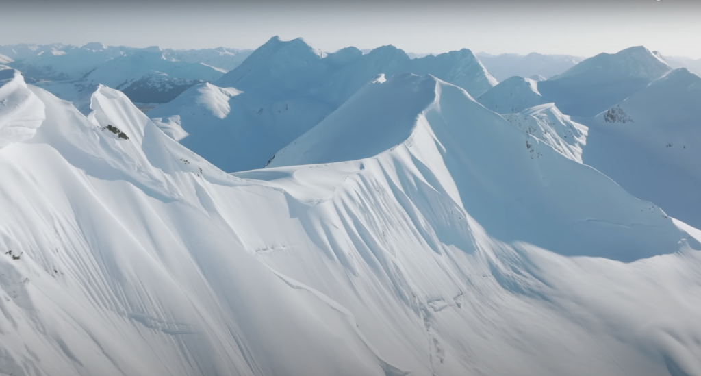 mountain tops shot from a drone in what can only be Alaska or similar mountain scape: Deep white steep mountain faces and ridge lines