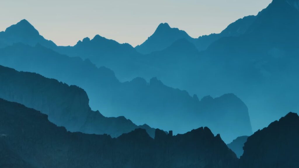 Silhouettes of mountain ridge behind mountain ridge in more than four layers, each a different shade of blue