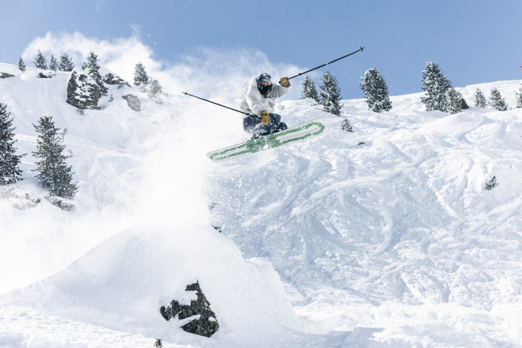 A skier takes air showing K2 ski bases 