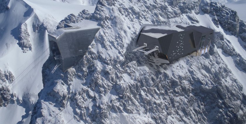 a james-bond-like building is built into the rock, high on a snow dusted mountain