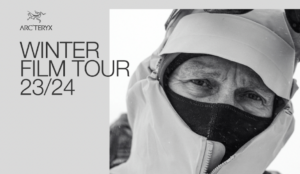 a poster ad for an Arcteryx film tour, a man's eyes just visible beneath hood and neck of jacket, staring seriously into the camera