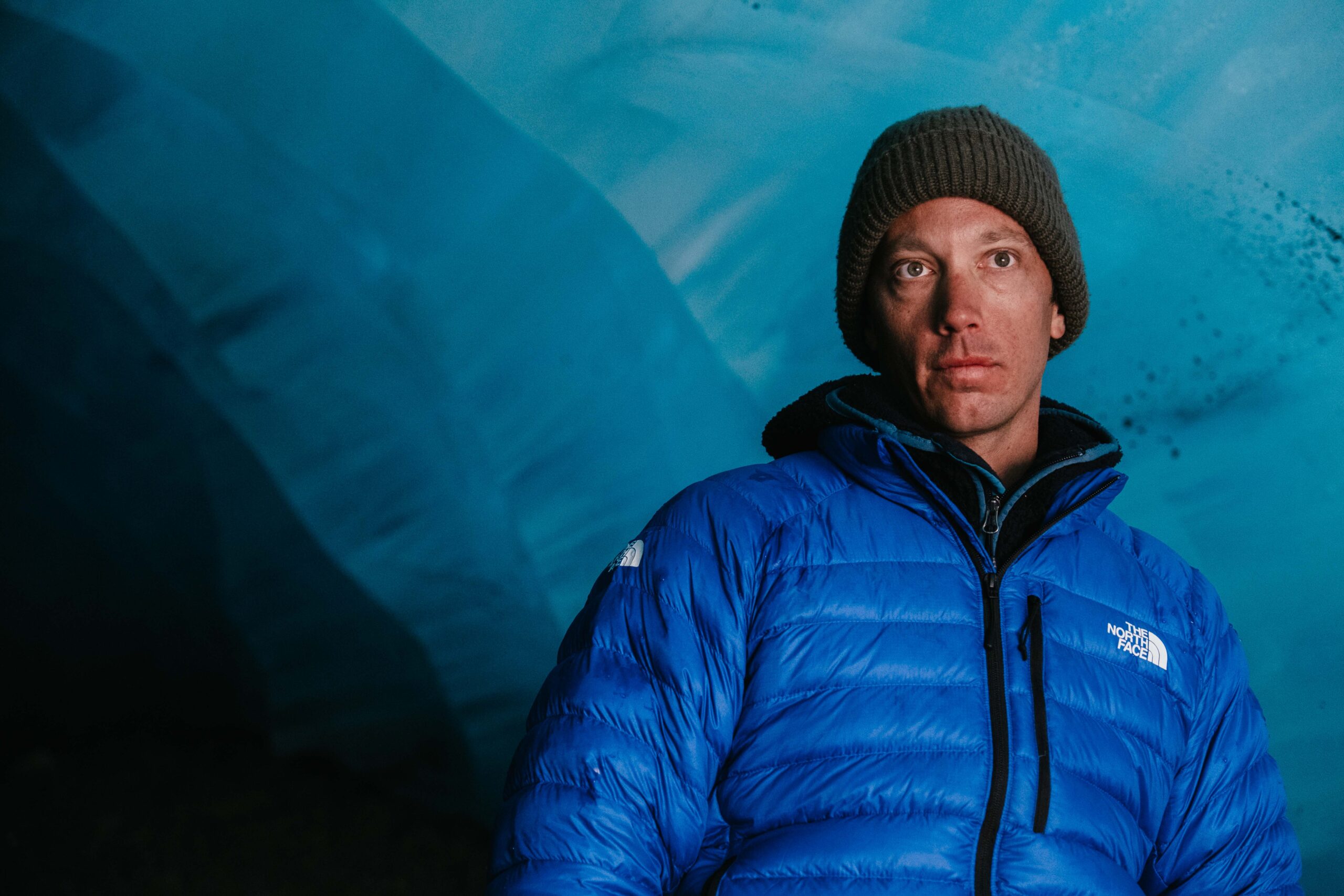 A profile image of the famous skier Sam Anthamatten in what looks like an ice cave, as he looks beyond the camera, unsmiling and serious