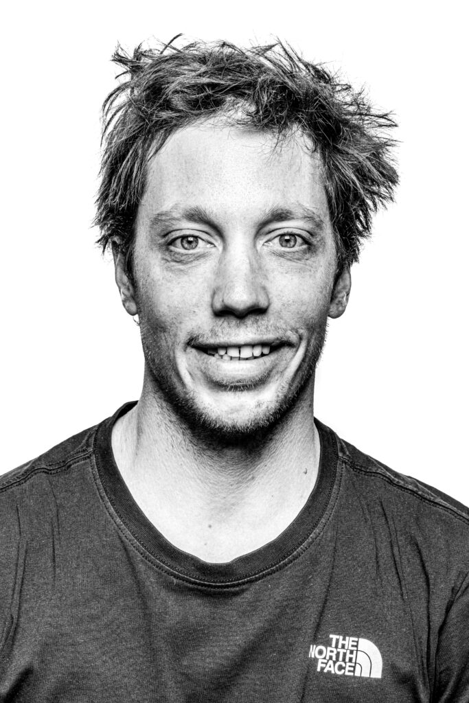 Black and white profile bio image of skier Sam Anthamatten smiling at camera