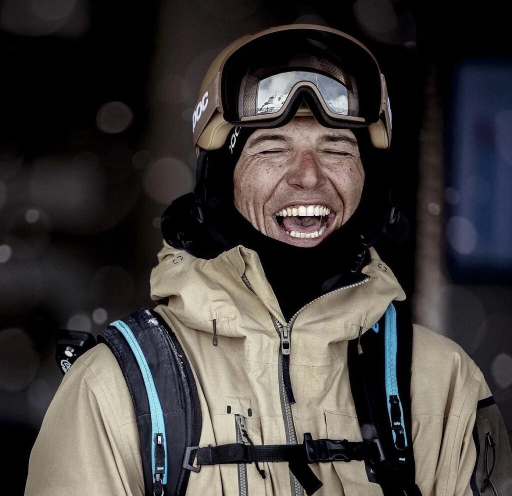 Skier tof henry laughs with eyes closed, dressed in beige photo, kitted up to ski