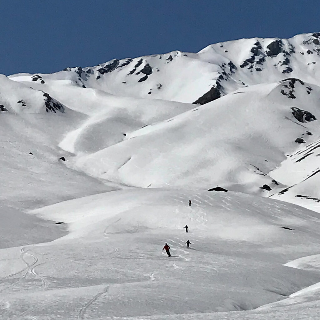 four skiers make fresh tracks in a snowy backcountry zone on a Grimentz powder quest