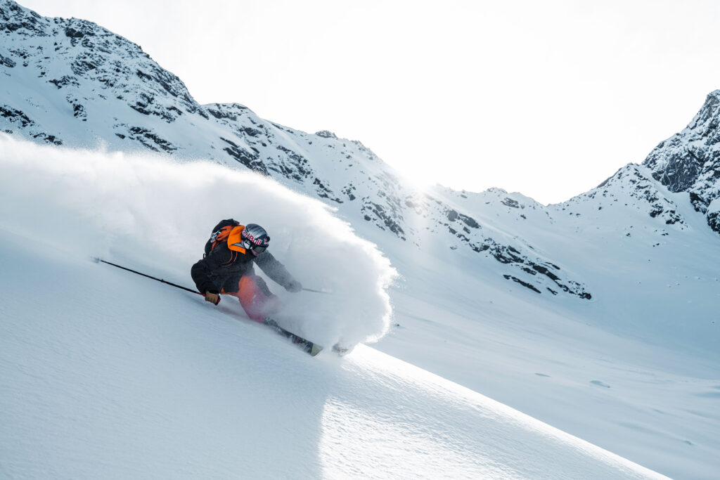 skier Markus Eder makes a beautiful turn on virgin snow, clouding up behind him