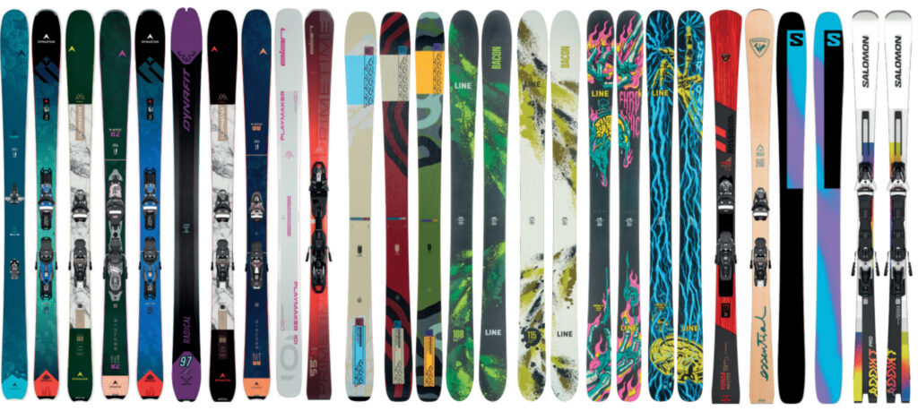 a dozen or more skis lined up on a white background