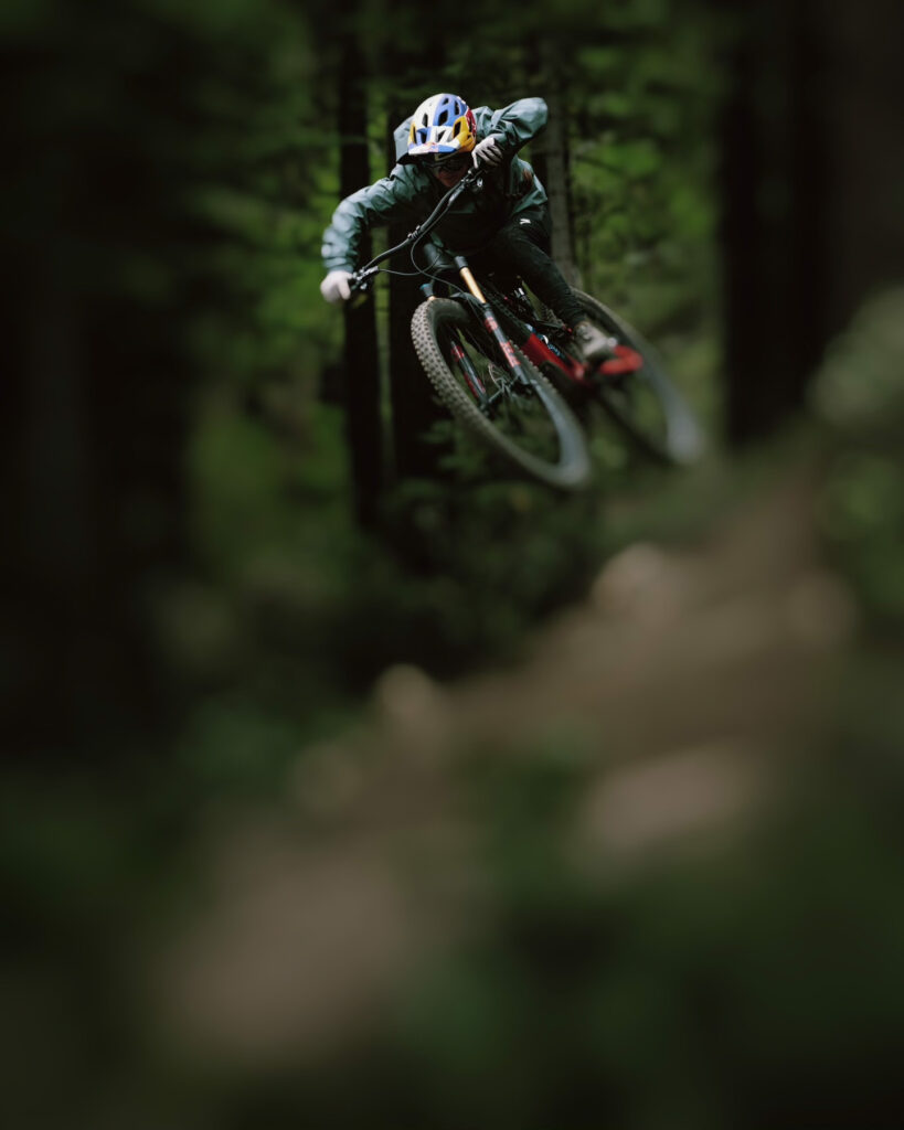 mountain biker takes air in moody, blurred out pro photographer shot
