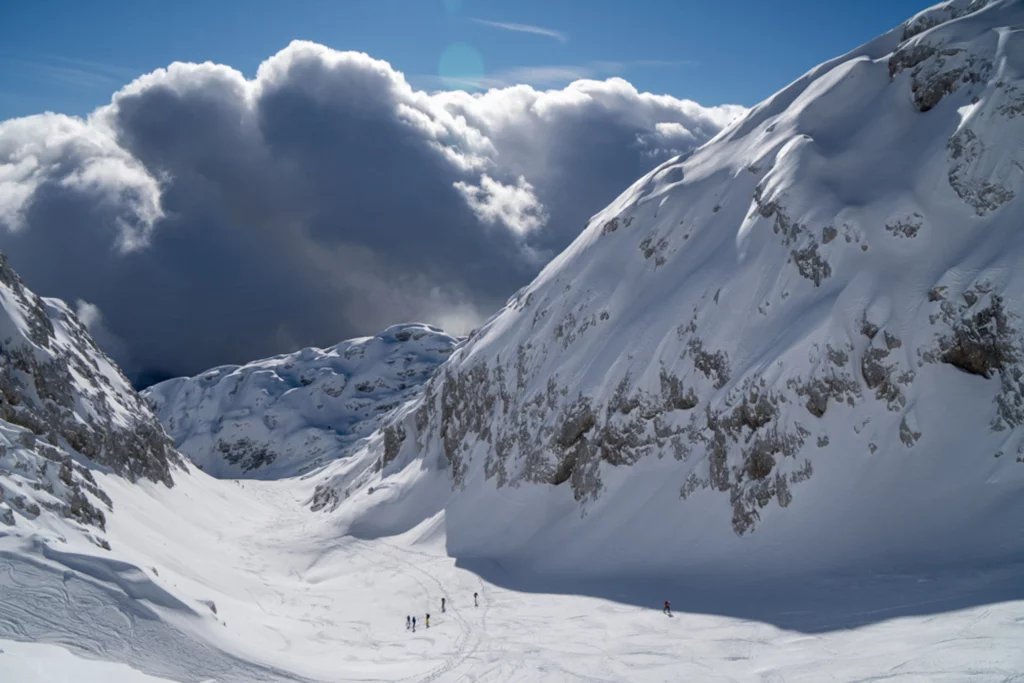 ski tourers in between two mountain peaks