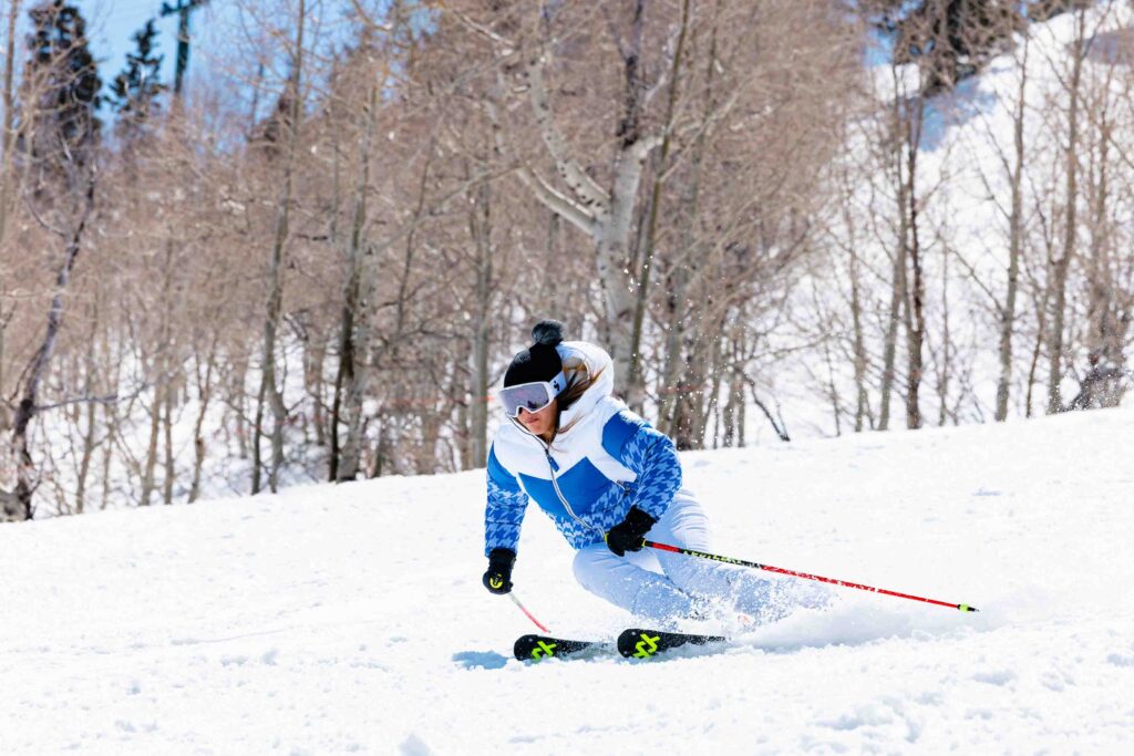 a skier on piste in a blue houndstooth puffer ski jacket