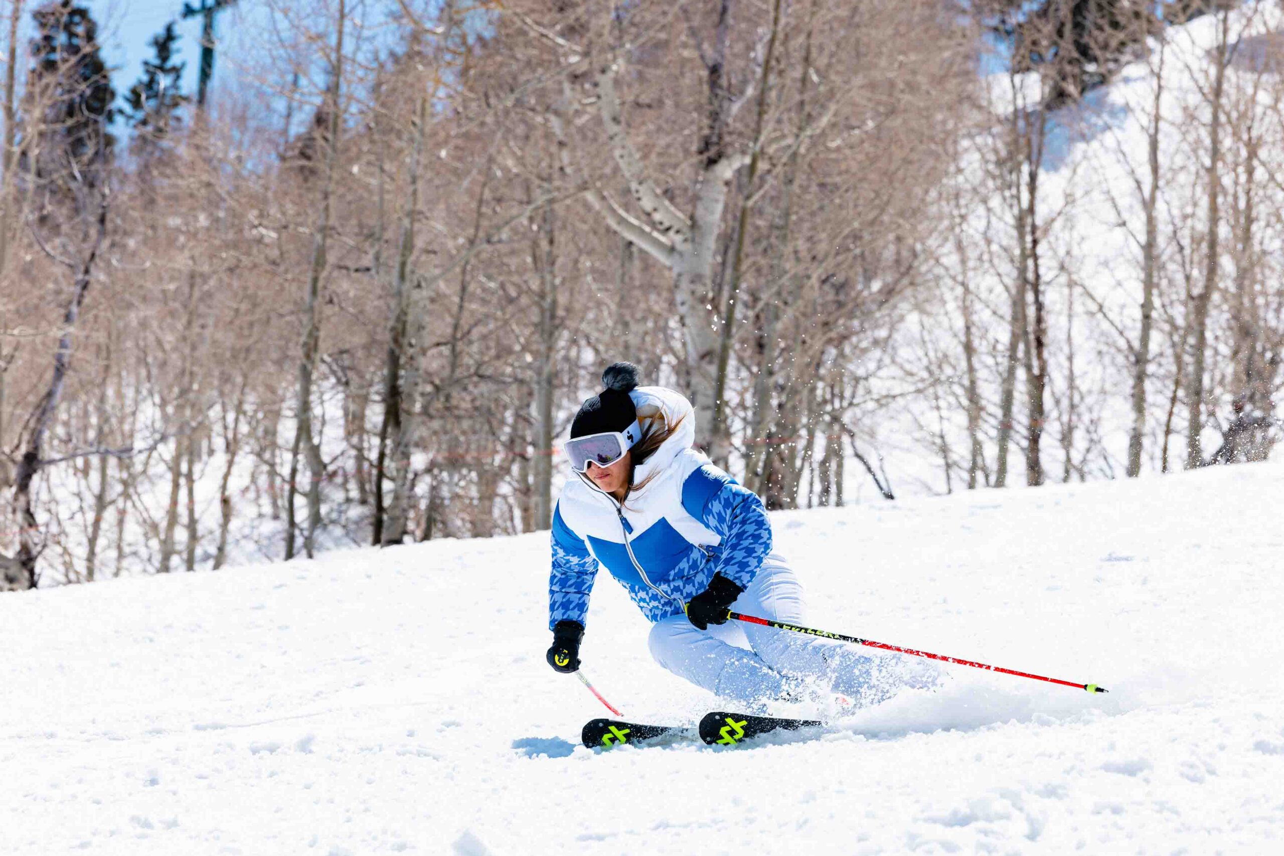 a skier on piste in a blue houndstooth puffer ski jacket