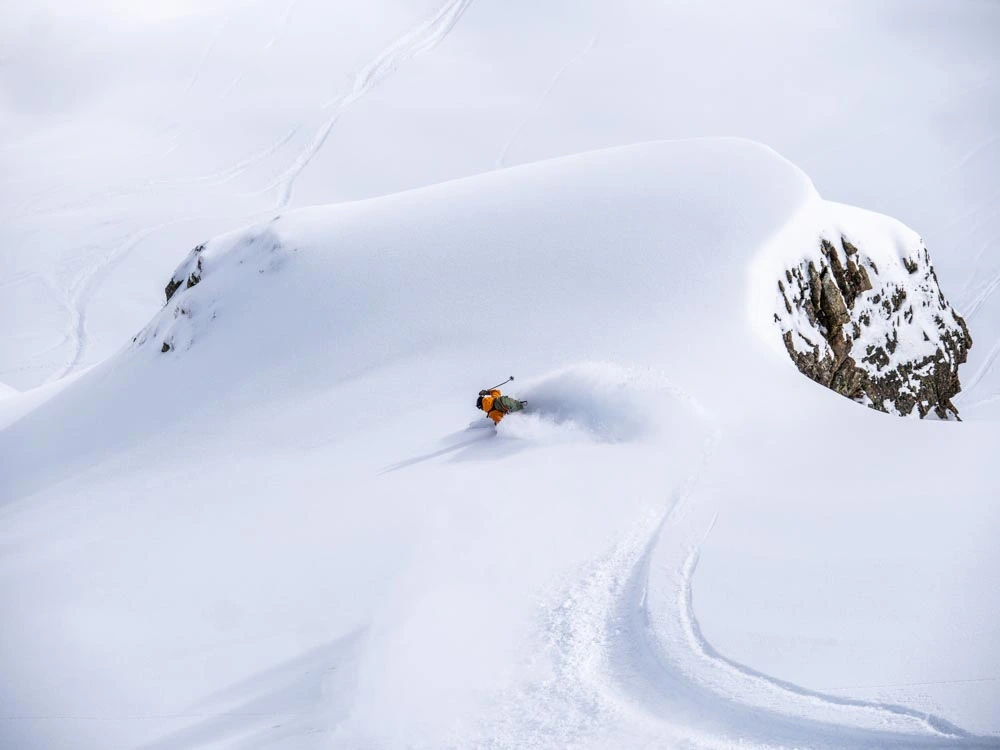 skier making a powder turn in backcountry, above treeline (no trees in shot)