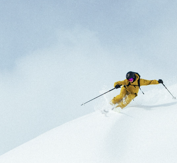 yellow skier, arms wide, freeriding