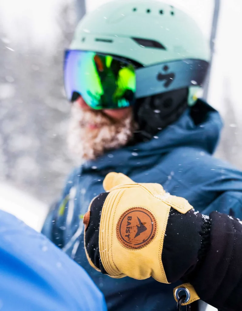 beardy man on chairlift, out of focus, his mitten the focus -  in a competition post to win Baïst gloves