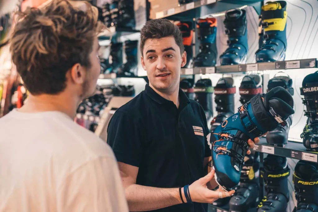 a boot fitter explaining to a customer