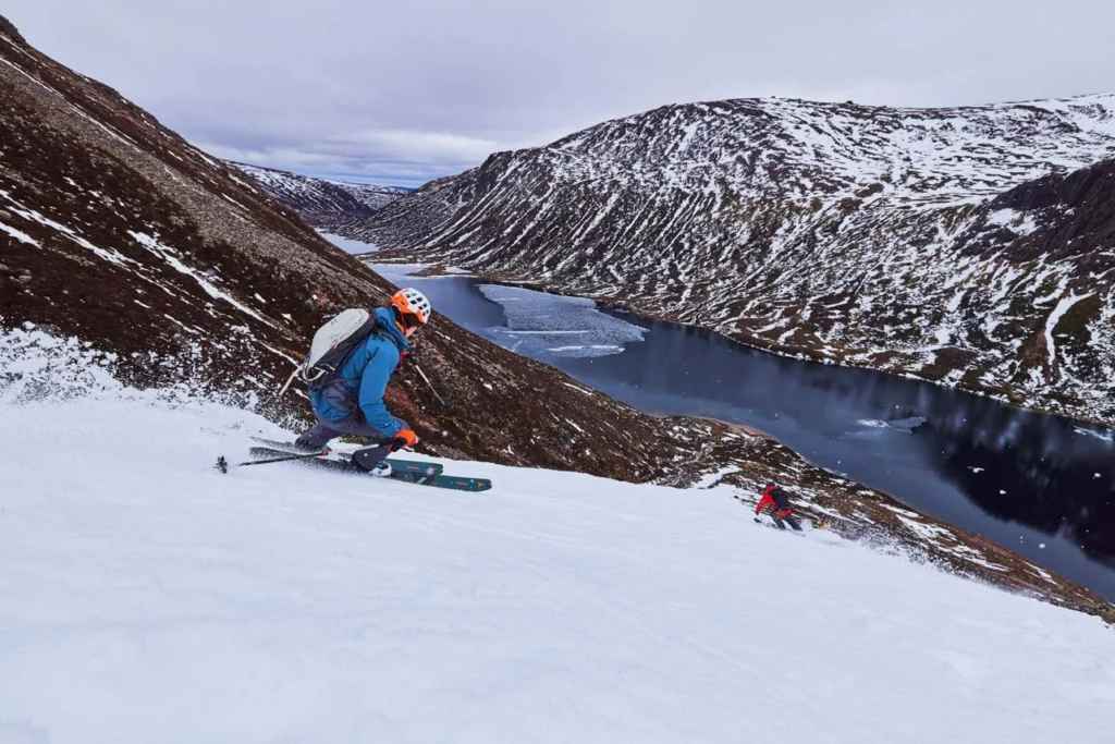 a skier descends towards a body of water