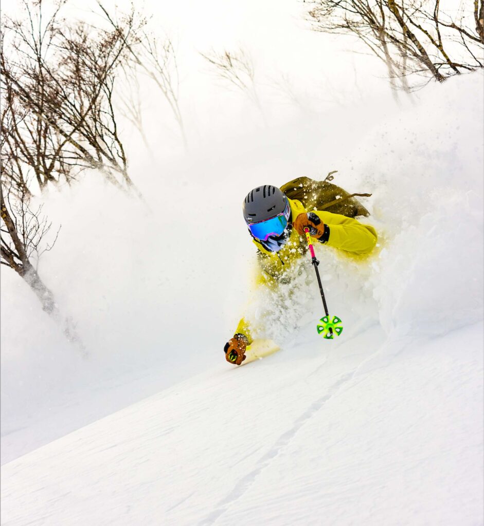 skier in yellow jacket in deep powder