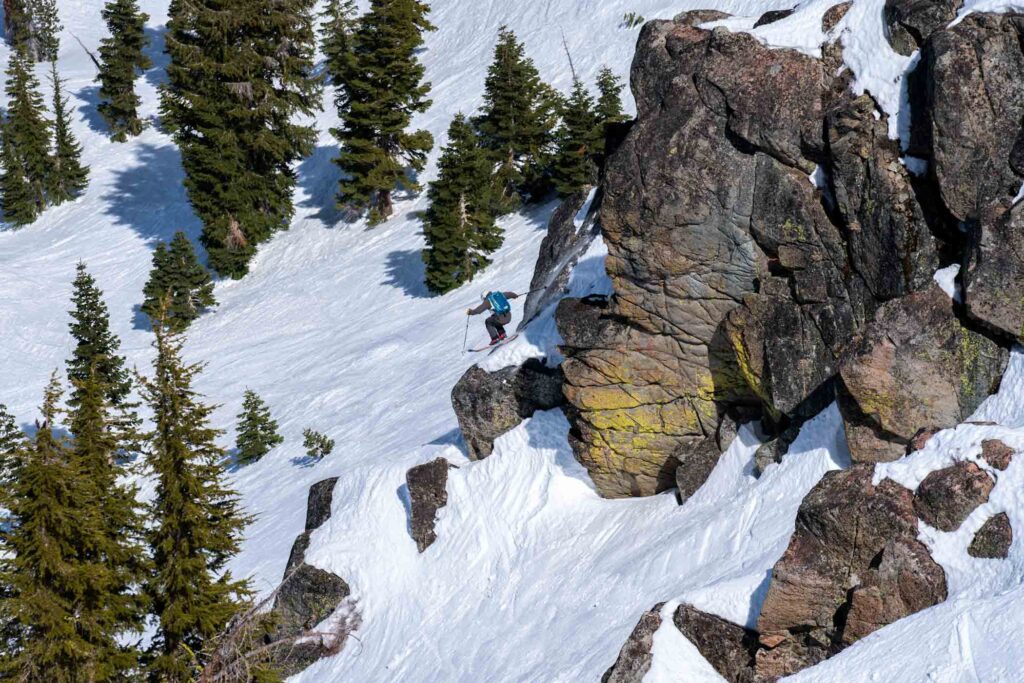 skier jumps over huge rocks