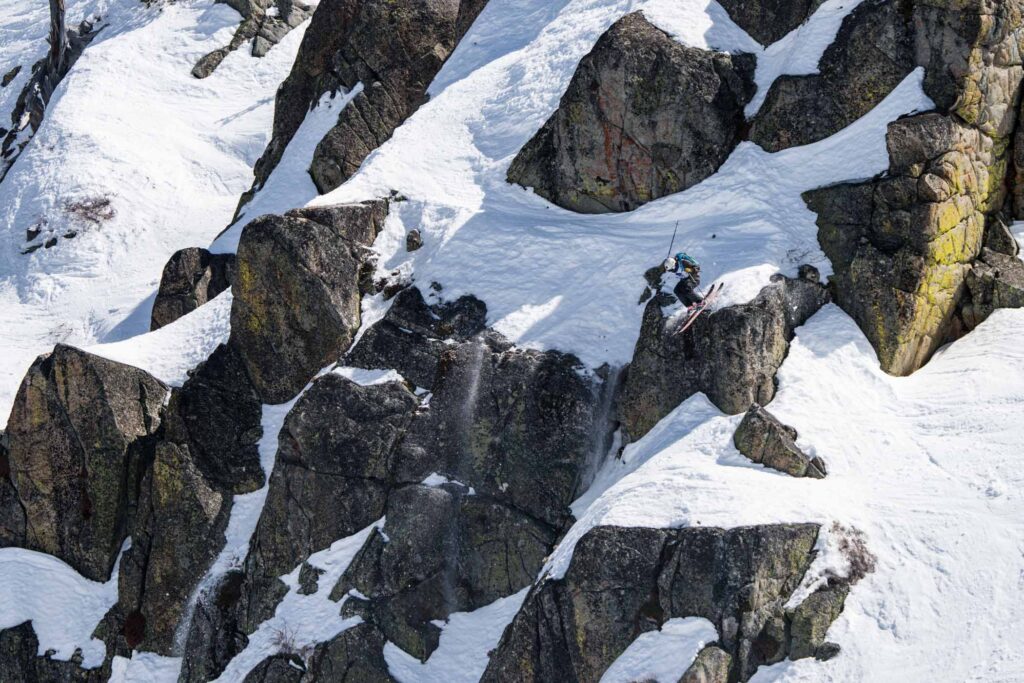 skier takes big air over huge rocks