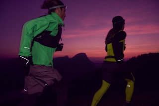 a pink sunset with two runners in bright colours on the move