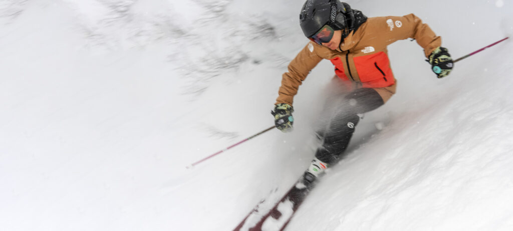 skier Ingrid Backstrom makes a beautiful turn on steep terrain, surrounded by snow and bad visibility