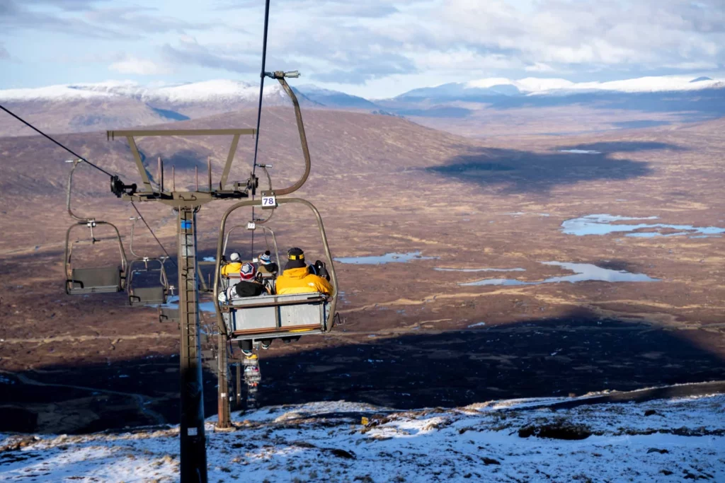 downloading on a Scottish chairlift, above a very Scottish landscape of red and brown valley, dotted with water