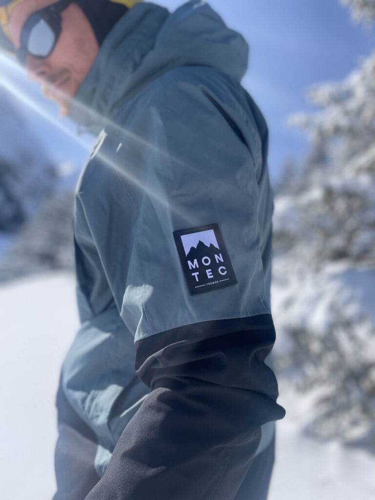 Montec ski brand label on ski jacket of man standing on mountain