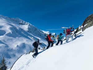 family ski touring, hiking upwards in fresh deep snow in high mountains