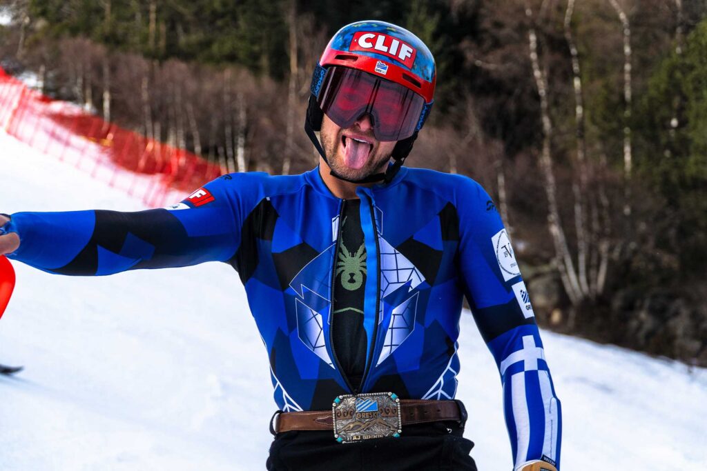 race skier, geared up, sticks tongue out to camera