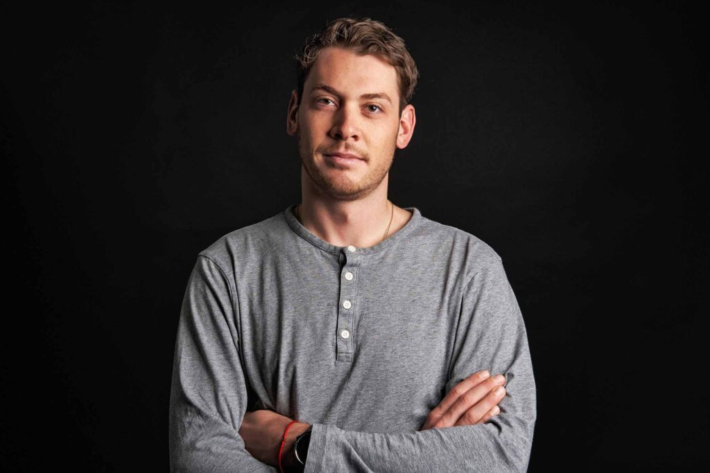 Fischer ski company's Global Product Manager for alpine boots, in his profile shot, arms crossed, against a black background