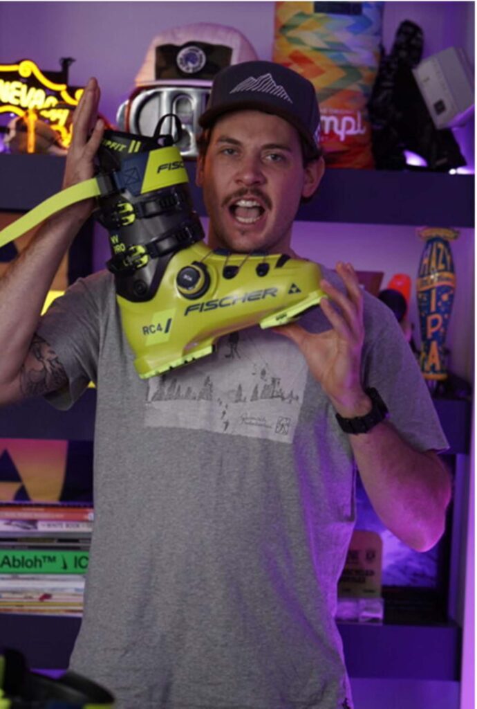 Fischer ski company's Global Product Manager for alpine boots, Christoph Lentz, holding a yellow Fischer RC4 ski boot